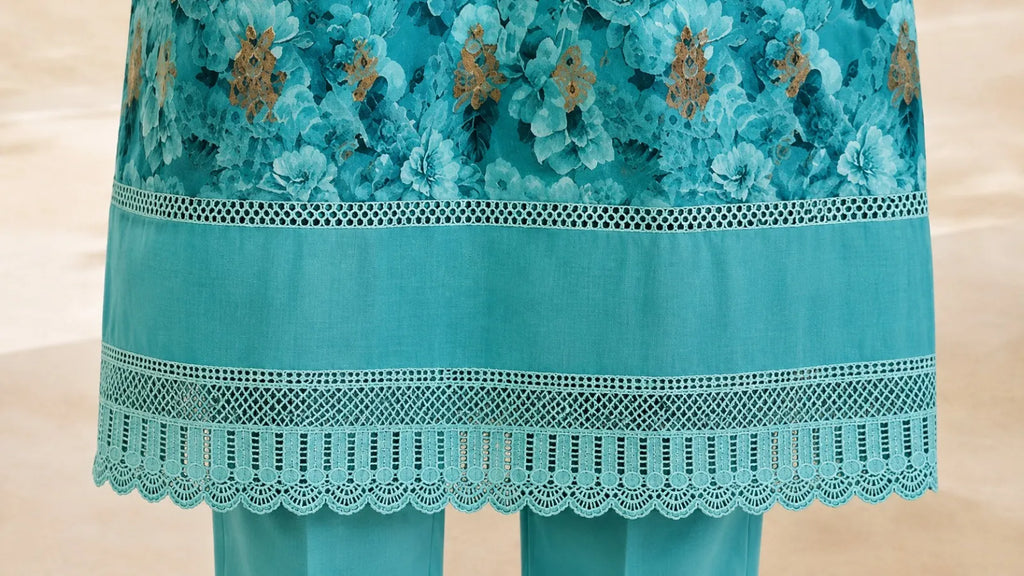 Teal embroidered garment with gold details on a beige background
