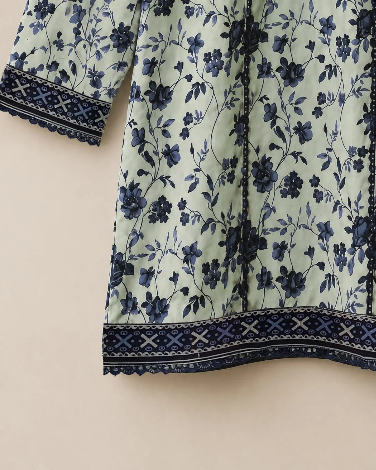 Floral patterned fabric with blue flowers on a light green background