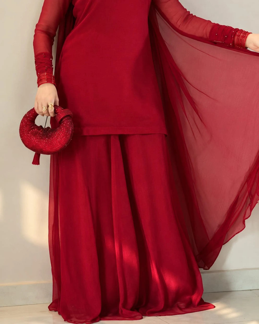 Flowy deep red sharara trousers paired with a matching shirt.