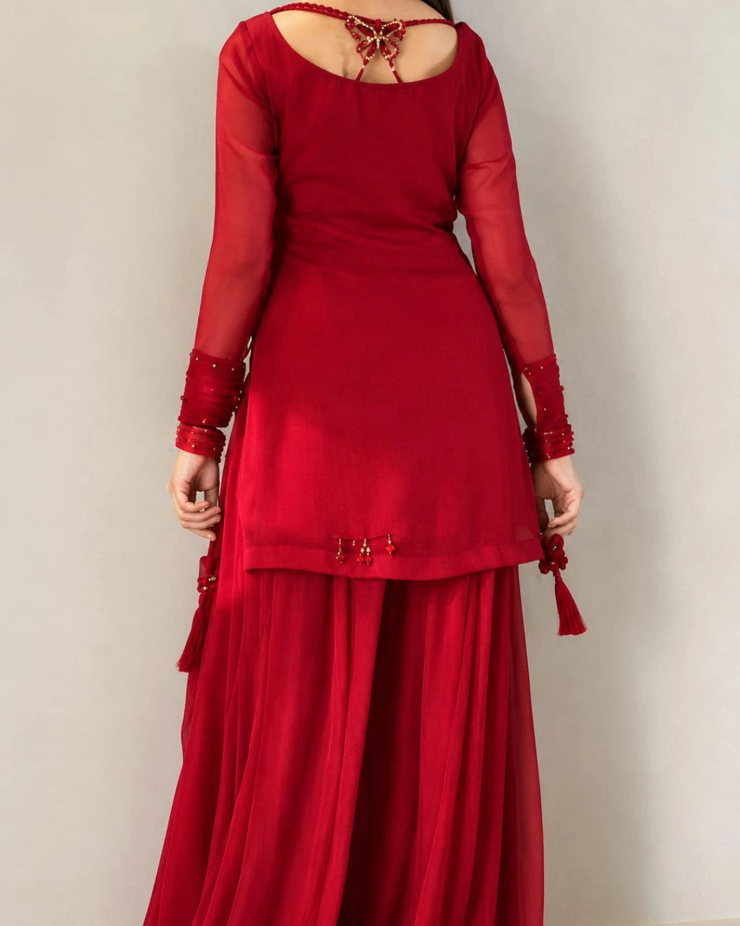Deep red Pakistani shirt with embellished neckline and 34-inch length.