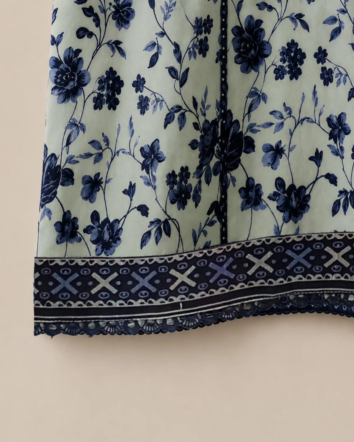 Close-up of a fabric with blue floral pattern on a beige background