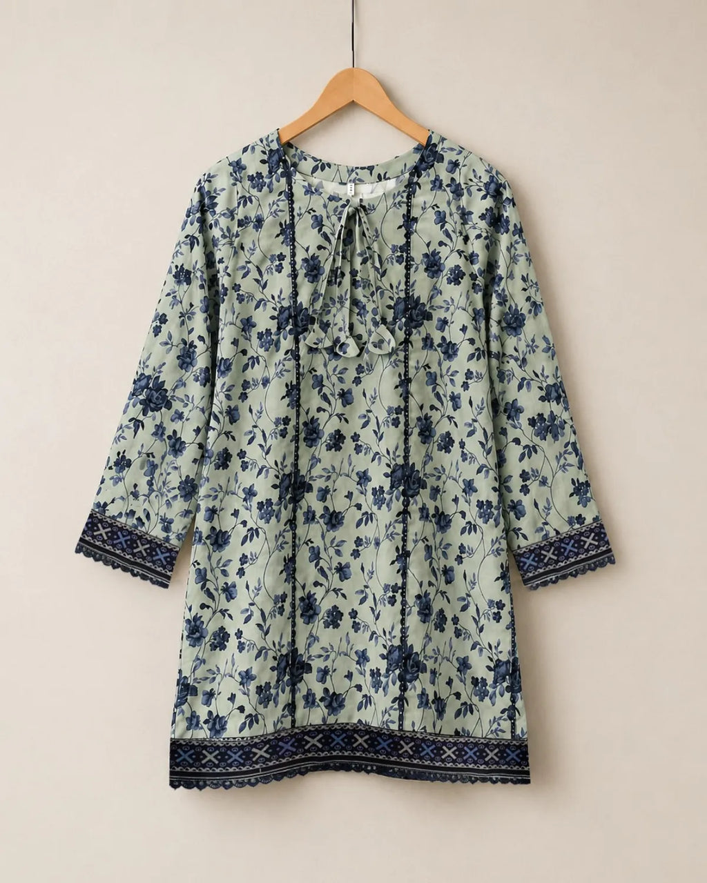 Floral patterned dress on a hanger against a beige background