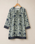 Floral patterned dress on a hanger against a beige background
