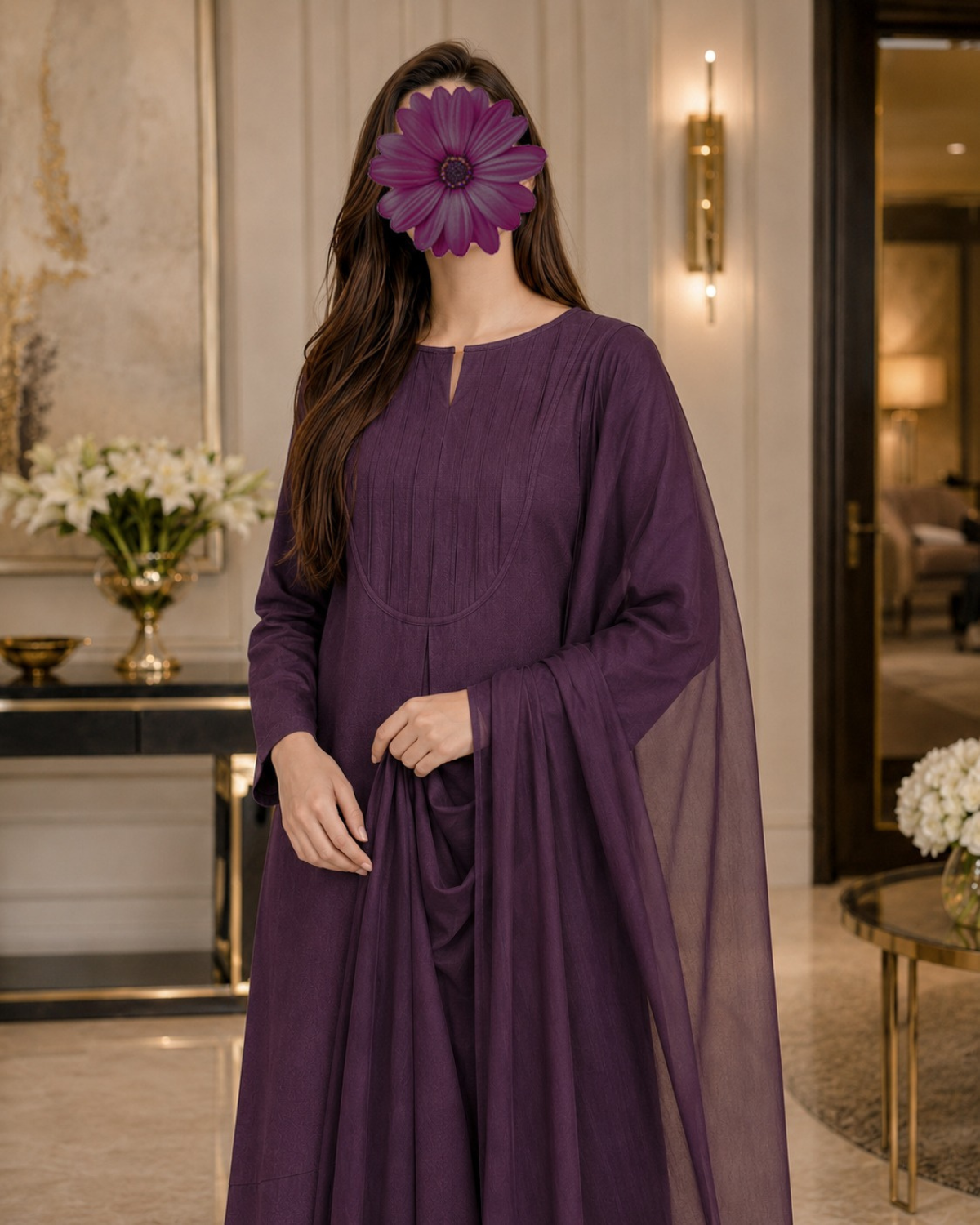 A woman wearing a long-sleeved purple traditional dress with a sheer draped overlay, standing in an elegant indoor setting with a decorative flower covering her face.
