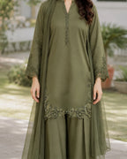 Woman wearing an olive green dress with embroidery outdoors