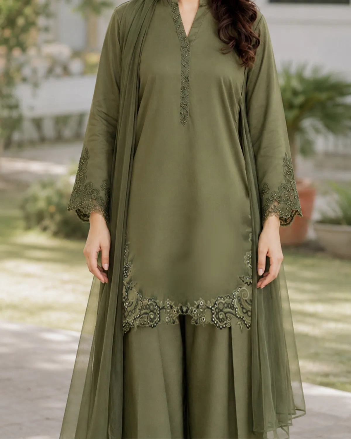 Woman wearing an olive green dress with embroidery outdoors
